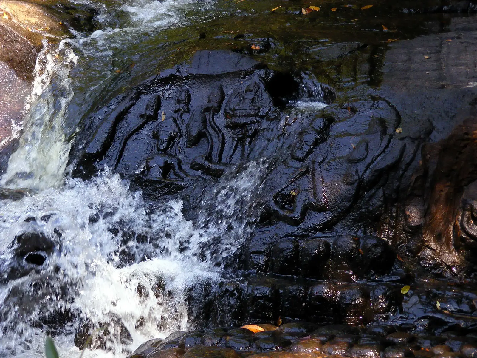 Sculptures hindoues taillées dans le lit de la rivière sous une cascade à Kbal Spean, près d’Angkor