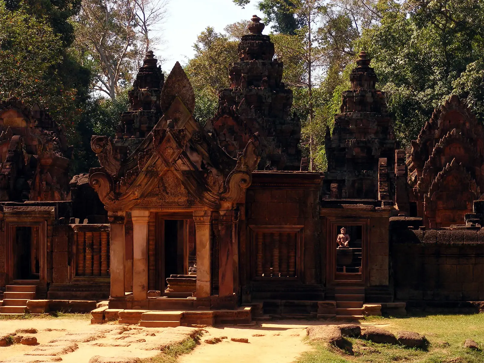 Sanctuaires en grès rose et gardien agenouillé au temple de Banteay Srei, près d’Angkor