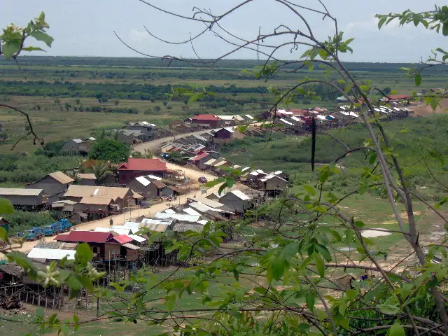 Village de maisons sur pilotis au bord d’une plaine inondable, vu depuis une colline au Cambodge