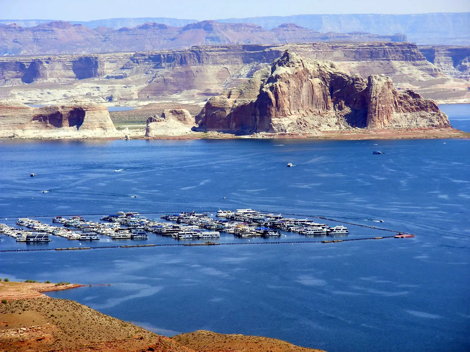 Marina de bateaux-maisons sur les eaux bleues du lac Powell, au pied d’une butte de grès rouge