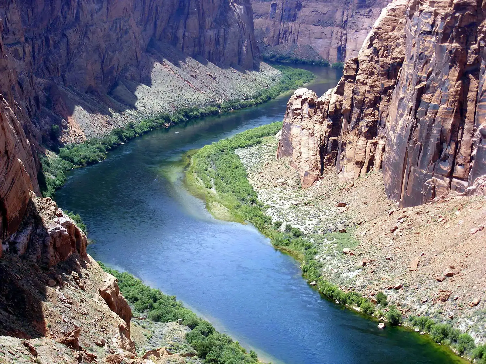 Le fleuve Colorado et ses rives vertes au fond d’un canyon de grès rouge près de Page