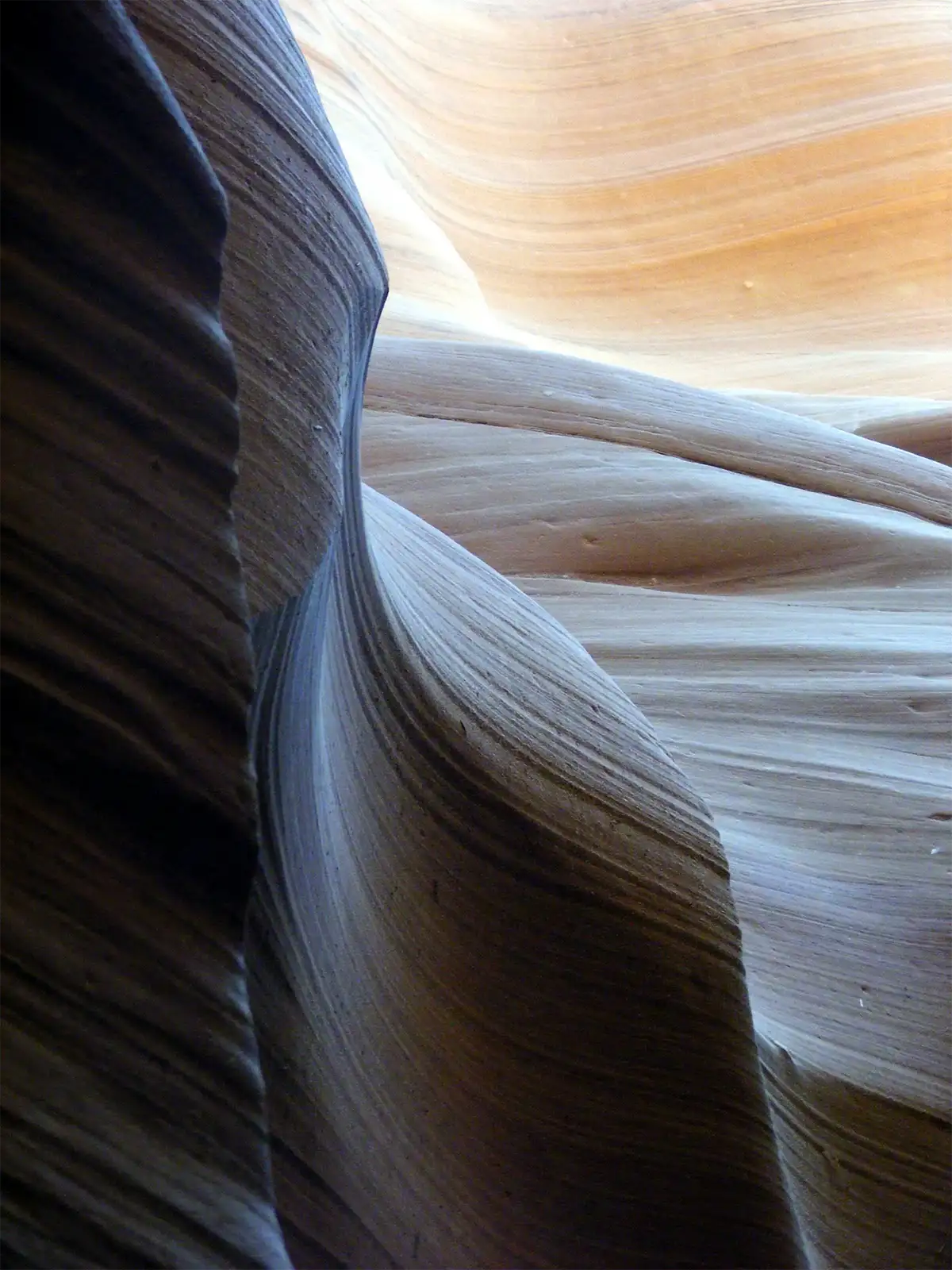 Courbes striées de grès gris et orangé dans l’étroit défilé d’Antelope Canyon