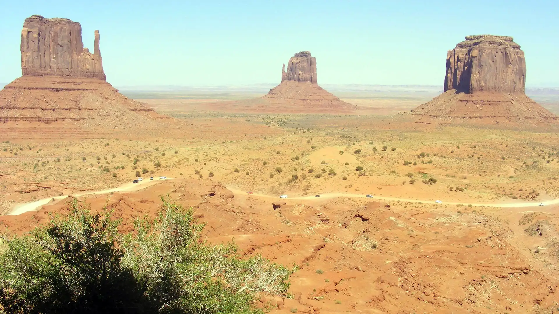Les deux Mittens et Merrick Butte dressés au-dessus de la vallée et de sa piste, à Monument Valley