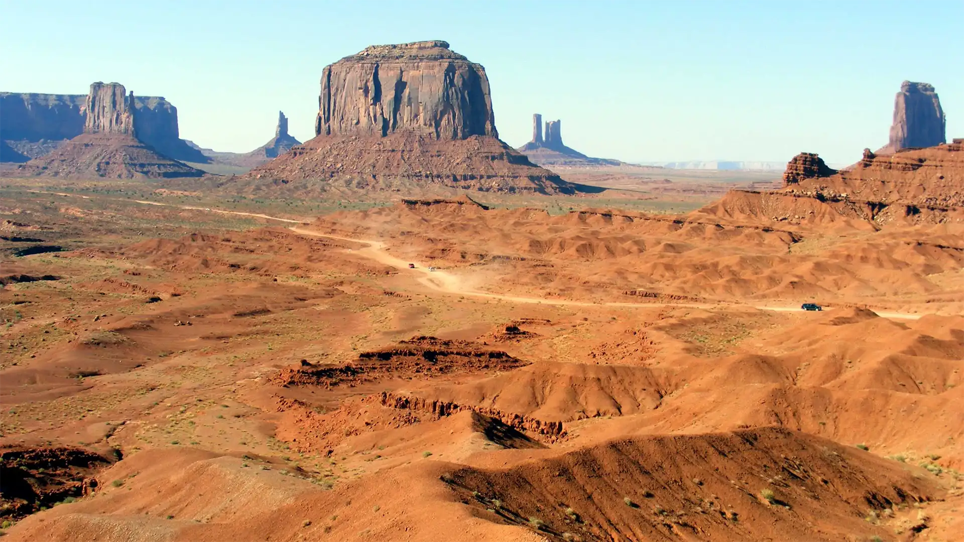 Pistes de sable rouge serpentant entre les buttes de Monument Valley, vues d’un point haut