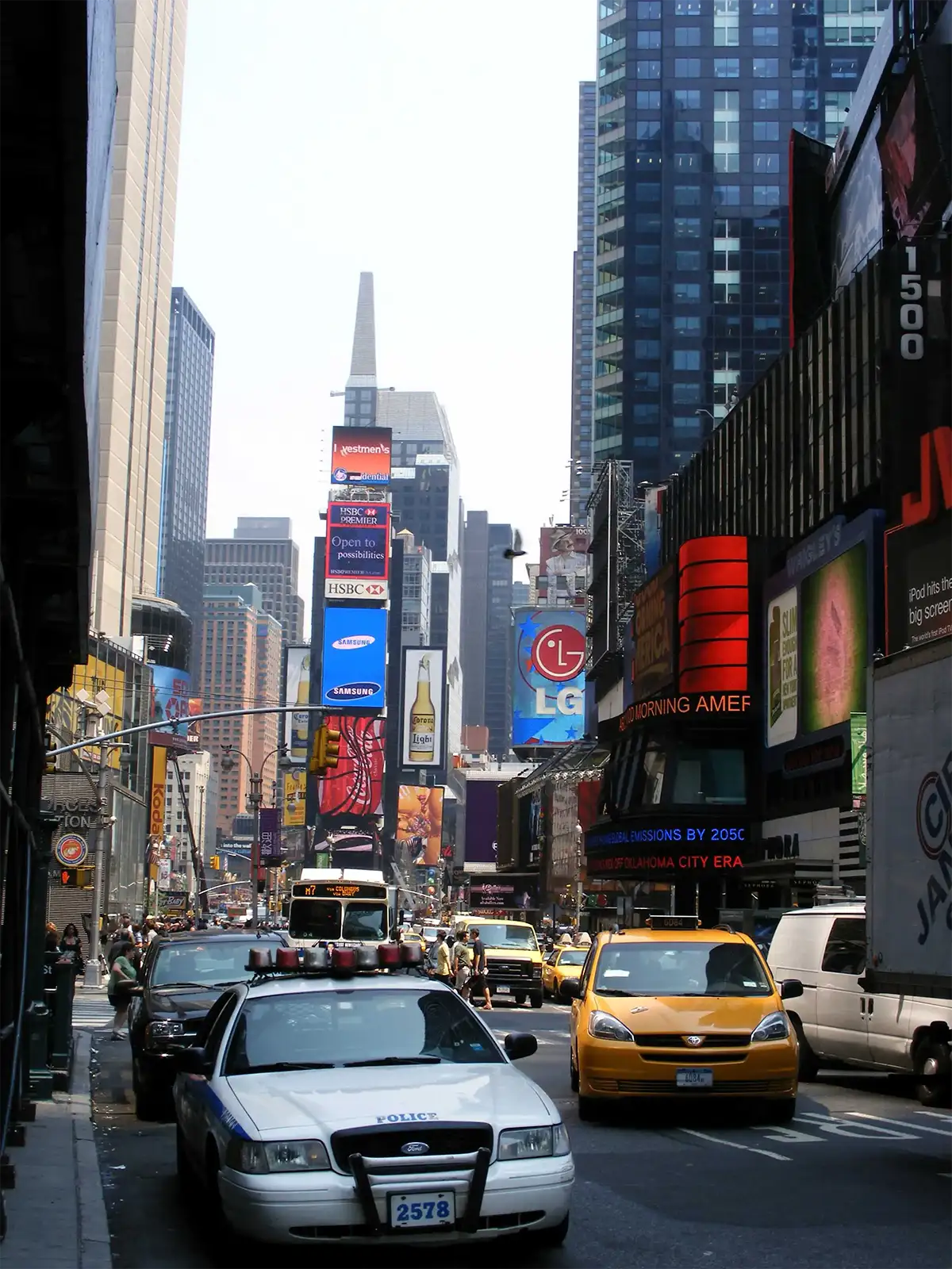 Taxis jaunes et voiture de police du NYPD sous les écrans géants de Times Square