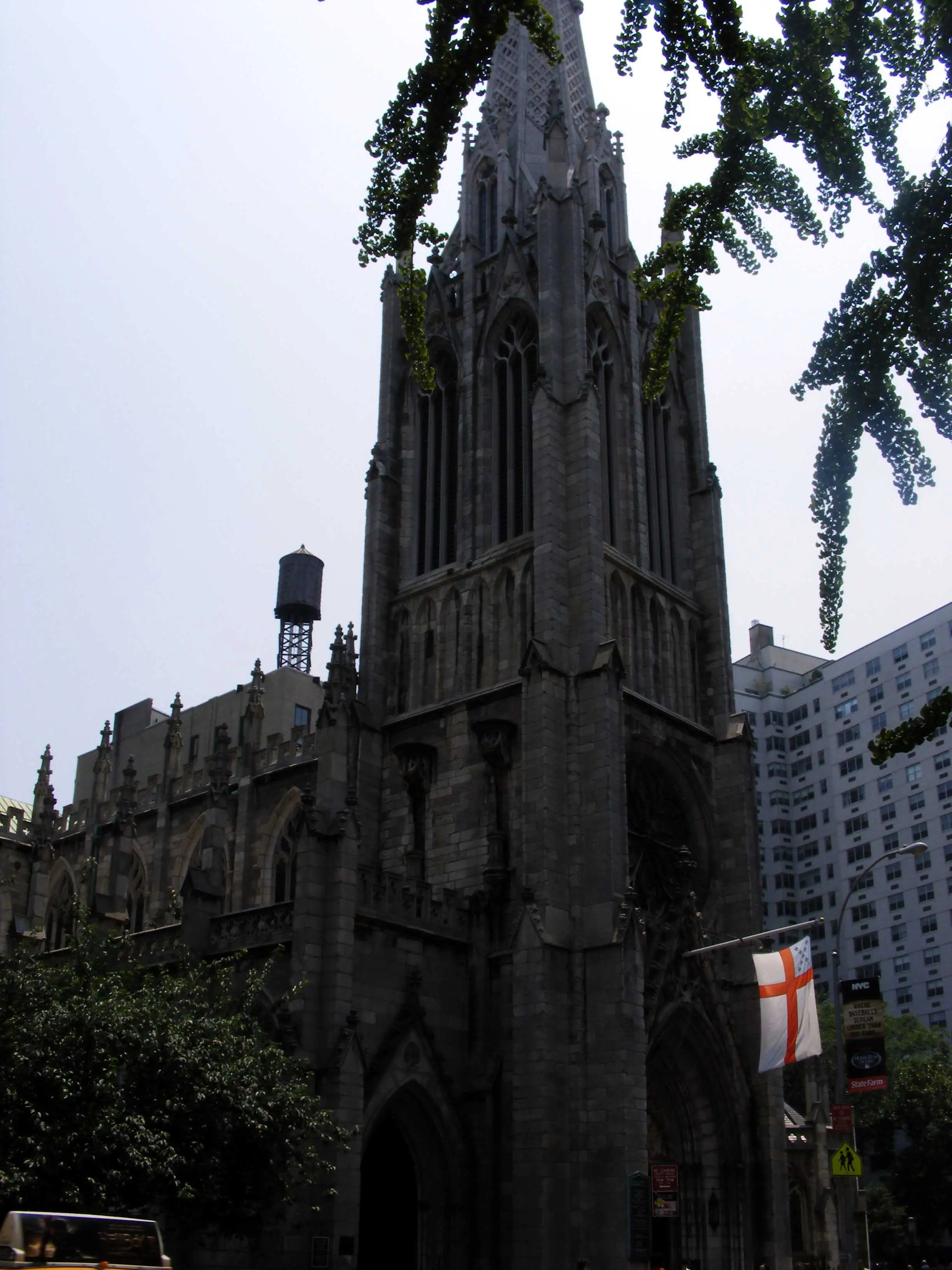 Clocher d’une église néogothique en pierre sombre et château d’eau à Manhattan