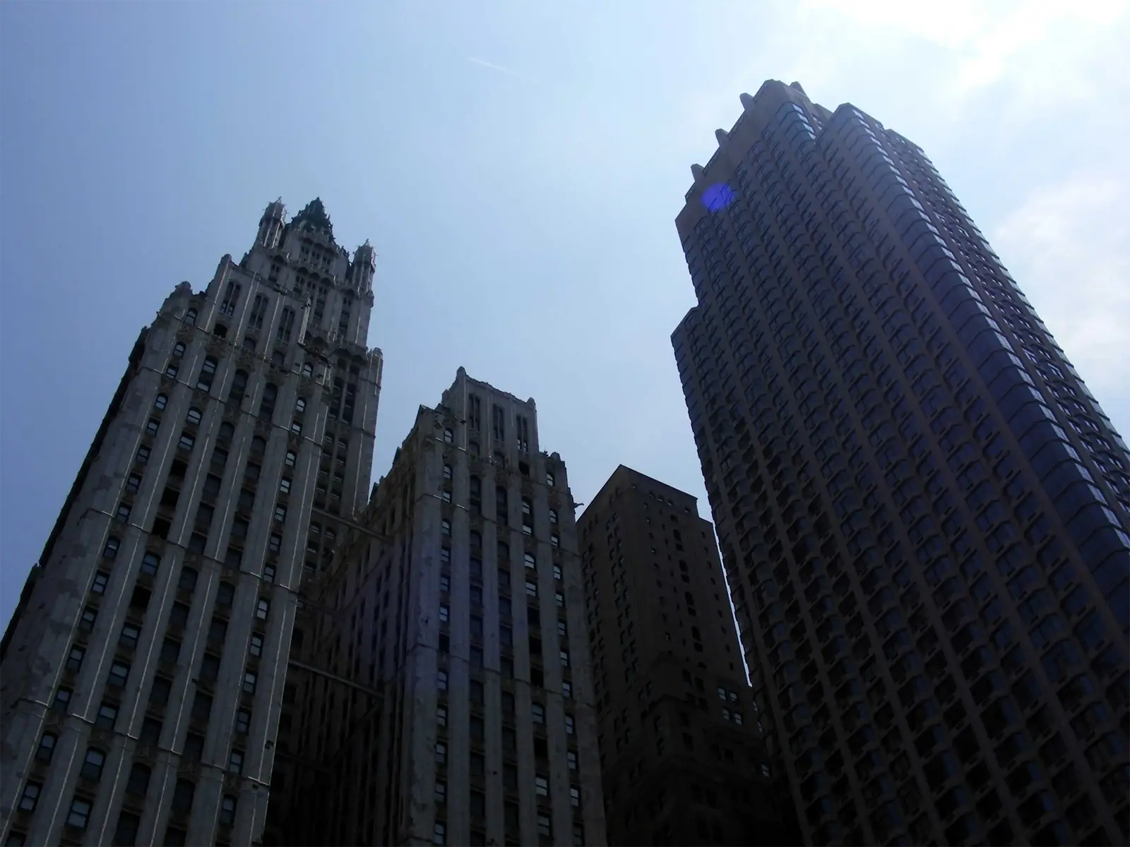 Le Woolworth Building et une tour de verre sombre vus d’en bas dans le sud de Manhattan
