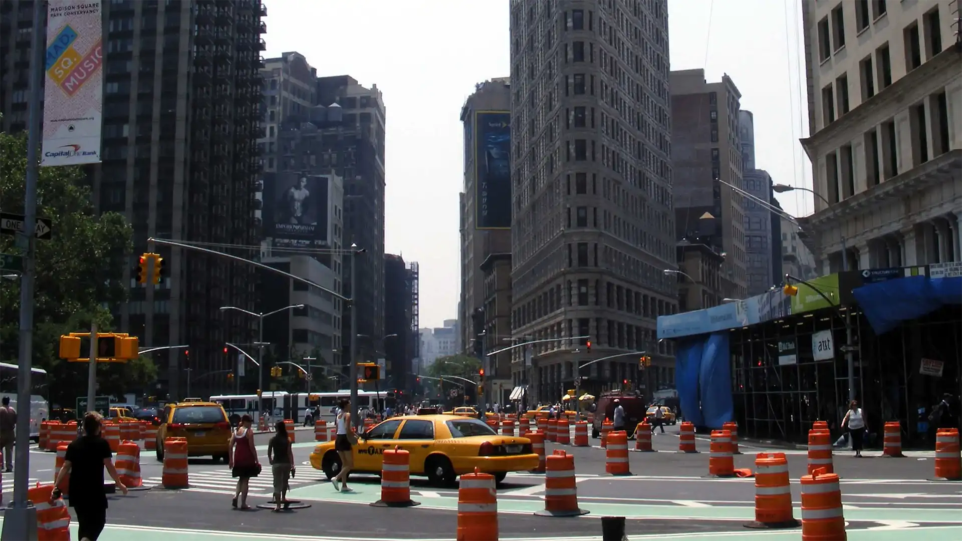 Taxi jaune et plots orange au carrefour du Flatiron Building, sur Broadway à Manhattan