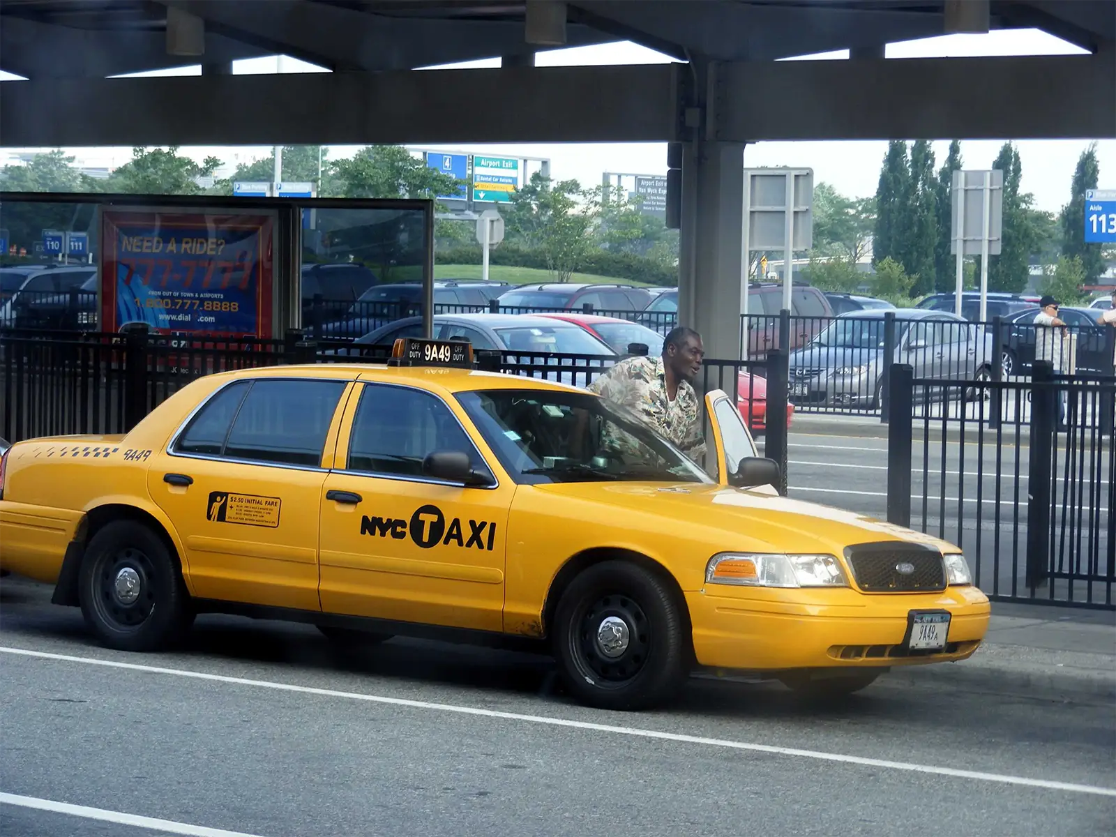 Taxi jaune de New York et un chauffeur à la station de taxis de l’aéroport