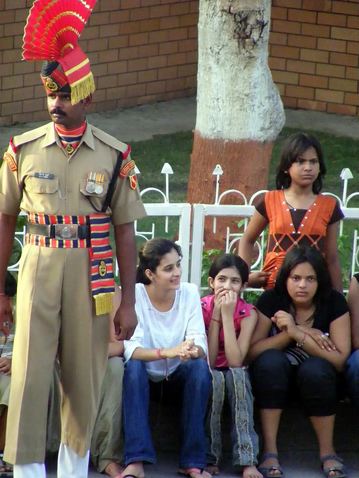 Garde-frontière indien en uniforme d’apparat devant de jeunes spectatrices à Wagah, près d’Amritsar
