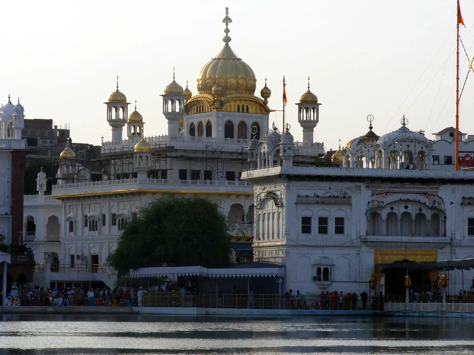 Édifices blancs à coupole dorée au bord du bassin du Temple d’Or d’Amritsar