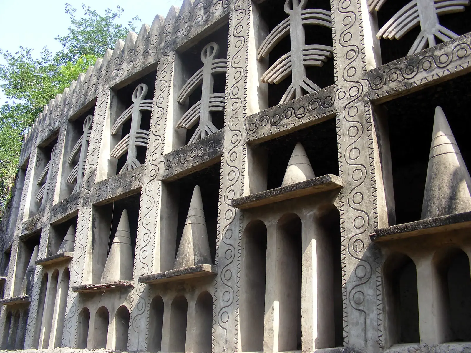 Mur de béton orné de figures stylisées et de cônes dans le Jardin des Rochers de Chandigarh