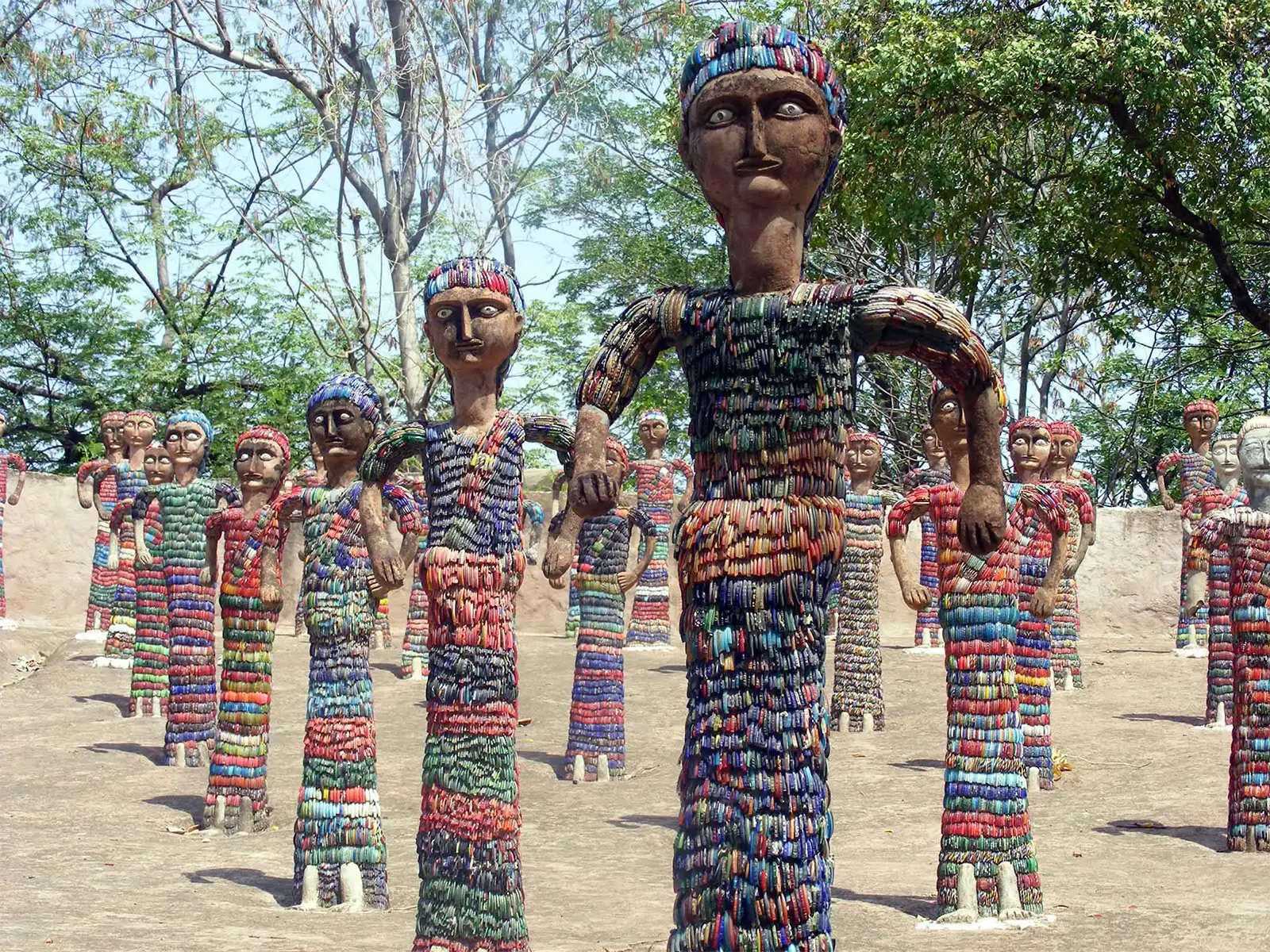 Armée de statues couvertes de bracelets colorés dans le Jardin des Rochers de Chandigarh