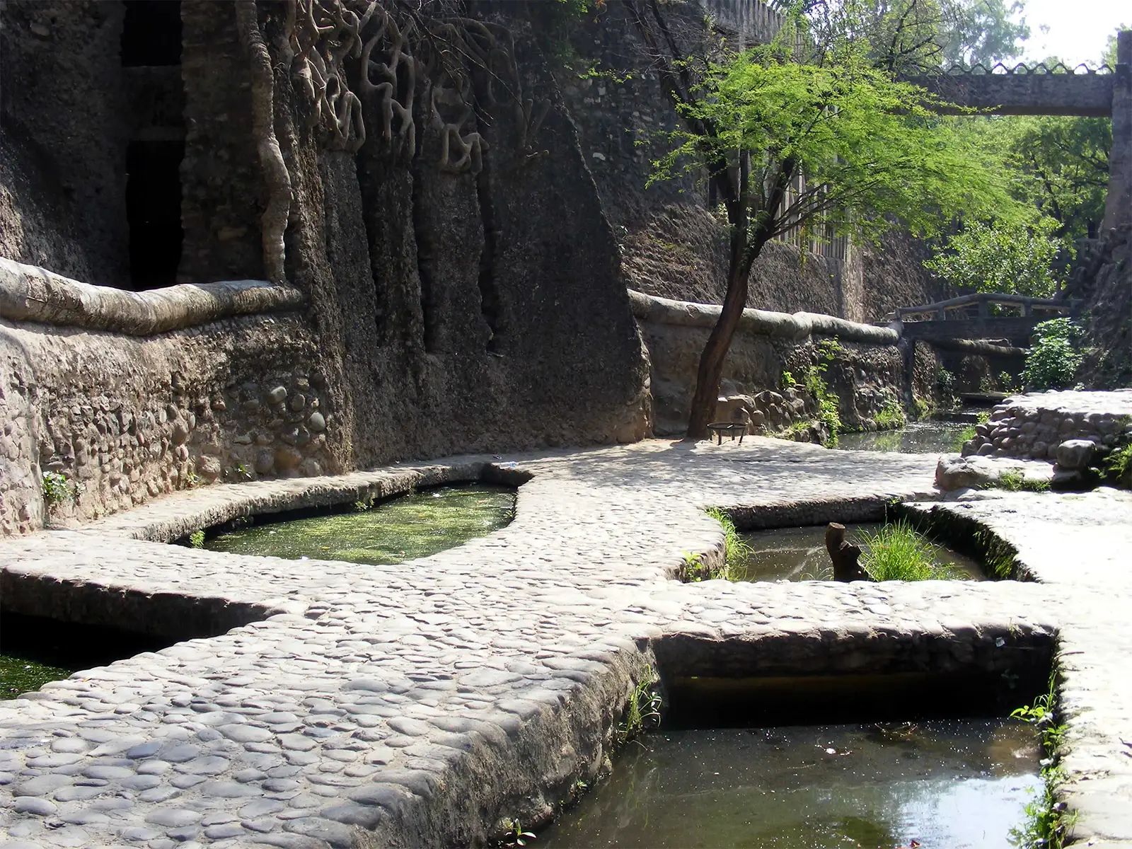 Bassins et chemins de galets entre des murs de pierre dans le Jardin des Rochers de Chandigarh