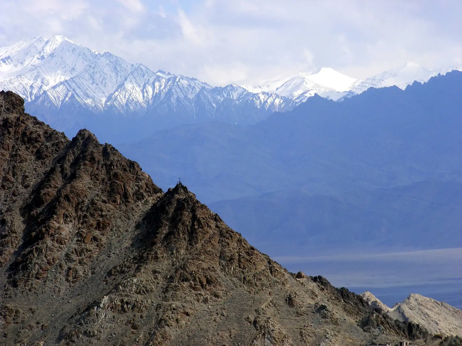 Crête rocheuse devant les sommets enneigés de l’Himalaya, aux environs de Leh