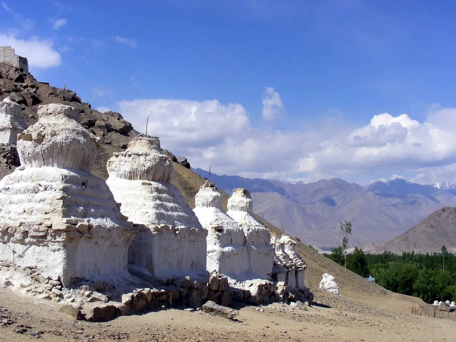 Rangée de chortens blancs à flanc de colline, face à la vallée de Leh
