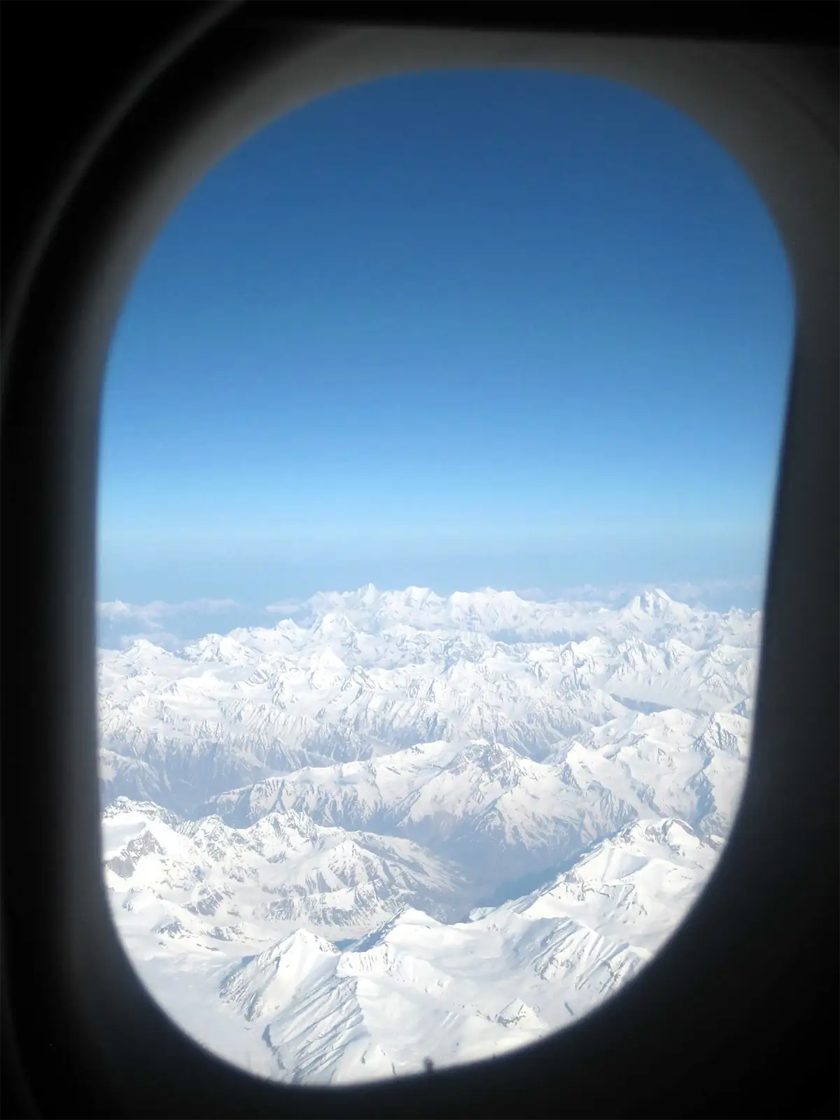 Chaîne himalayenne enneigée vue par le hublot de l’avion entre Delhi et Leh