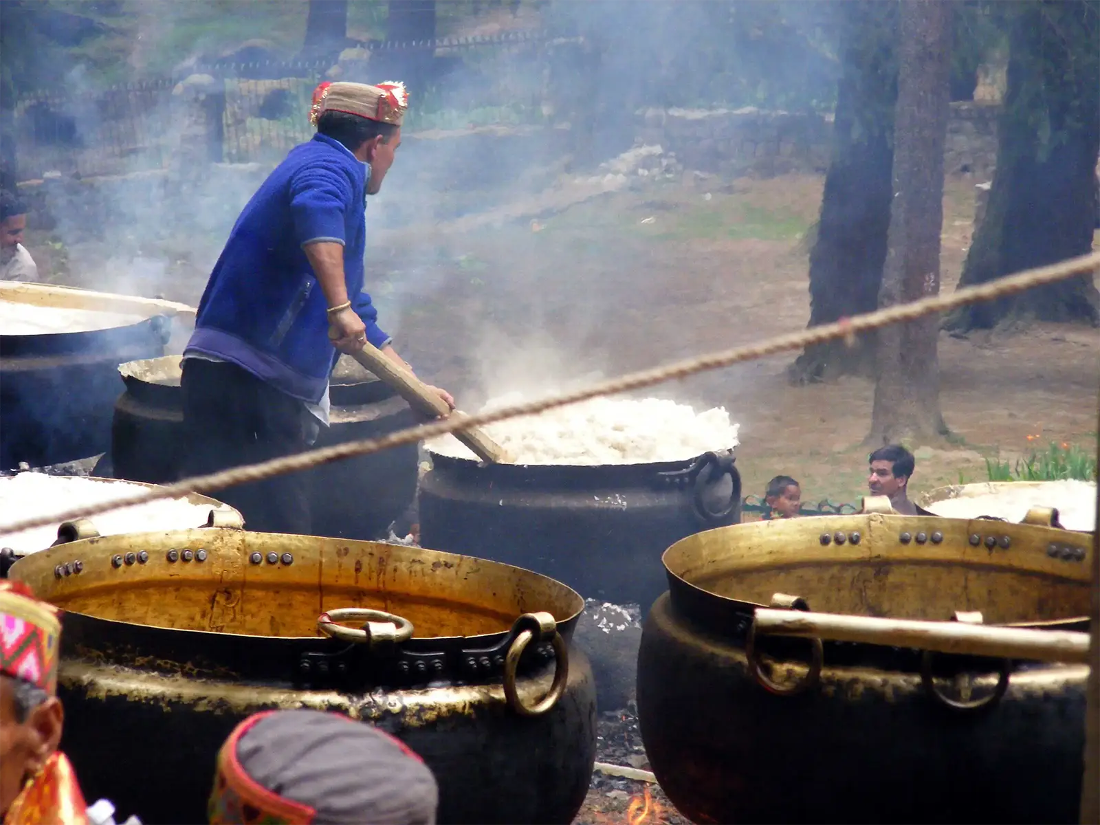 Riz cuit dans de grands chaudrons de cuivre pour une fête religieuse à Manali