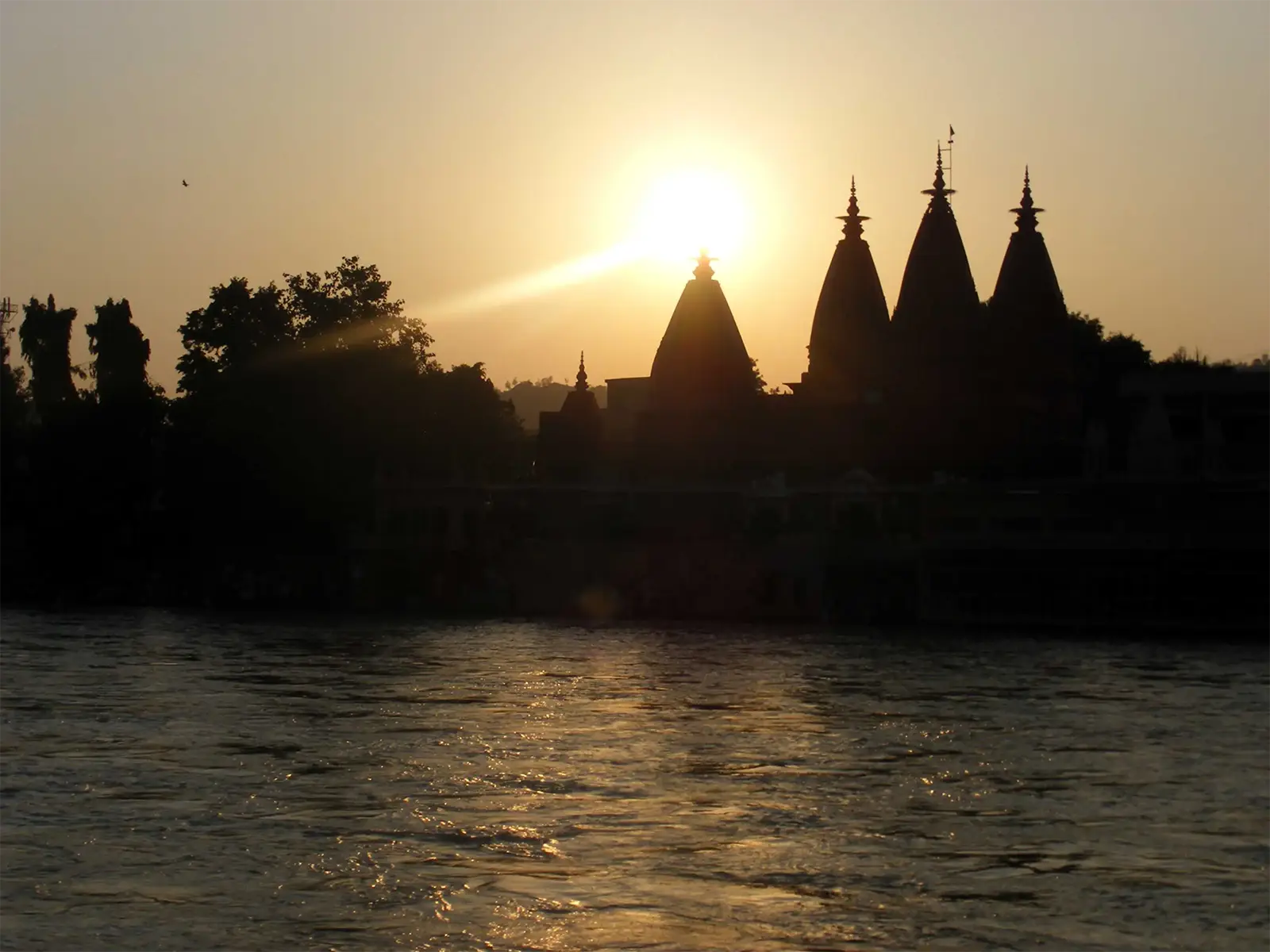 Silhouettes de temples hindous au coucher du soleil sur le Gange à Haridwar