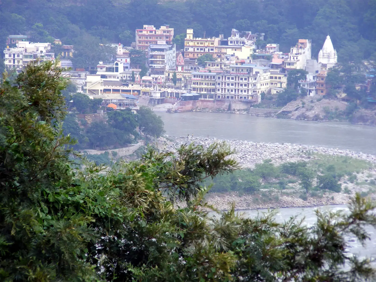 Les immeubles et temples de Rishikesh au bord du Gange, vus depuis les hauteurs boisées