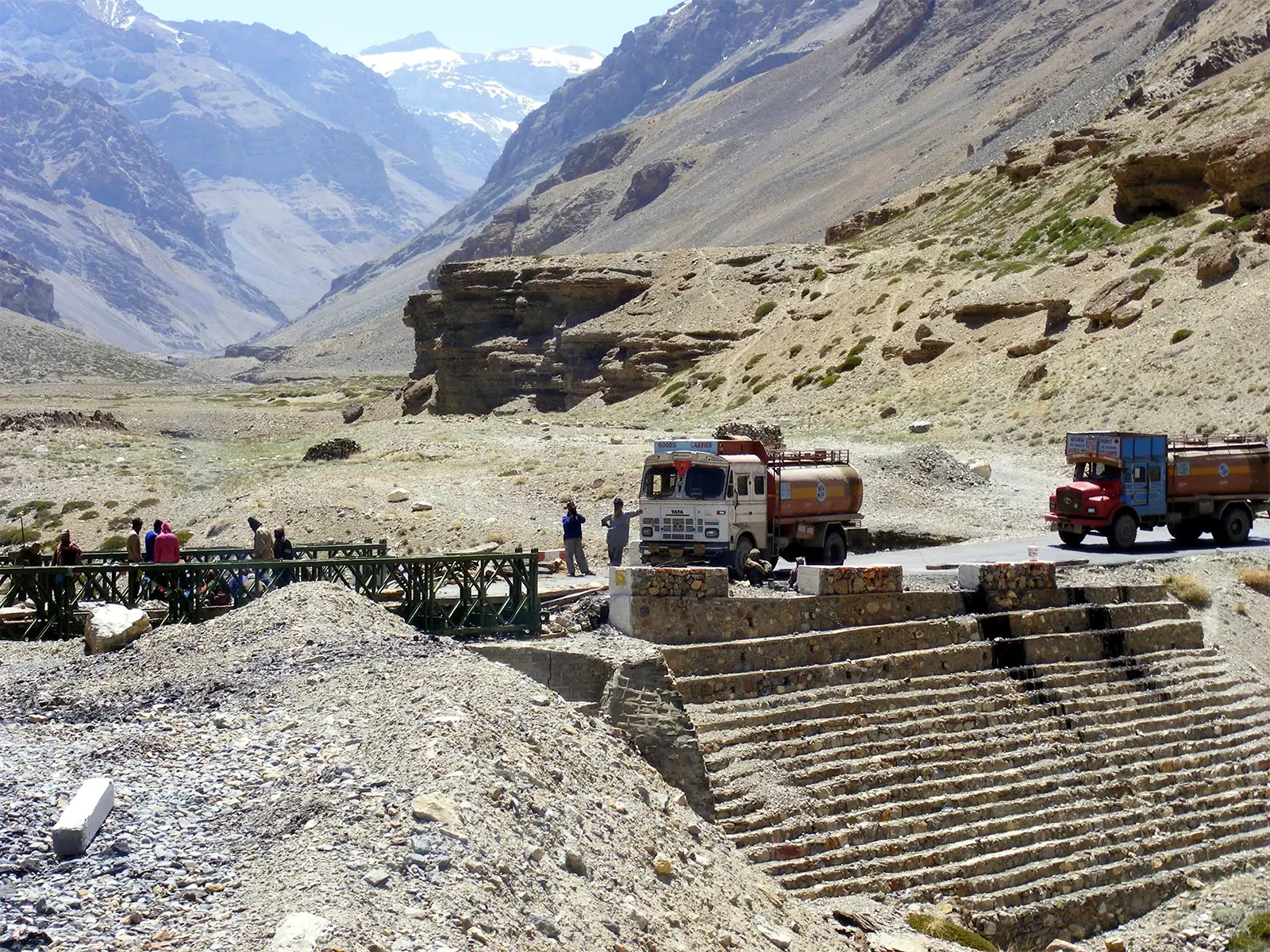 Camions-citernes et pont métallique dans une vallée minérale sur la route Leh–Manali