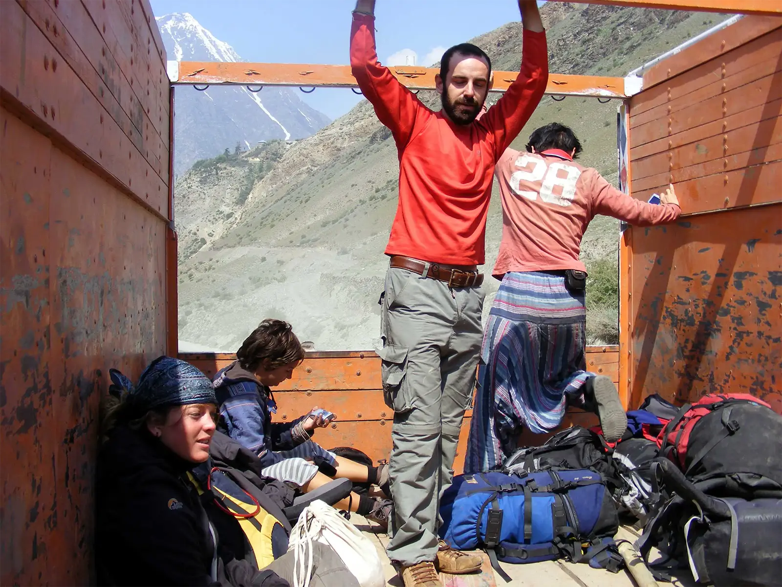 Voyageurs et sacs à dos à l’arrière d’un camion sur la route Leh–Manali