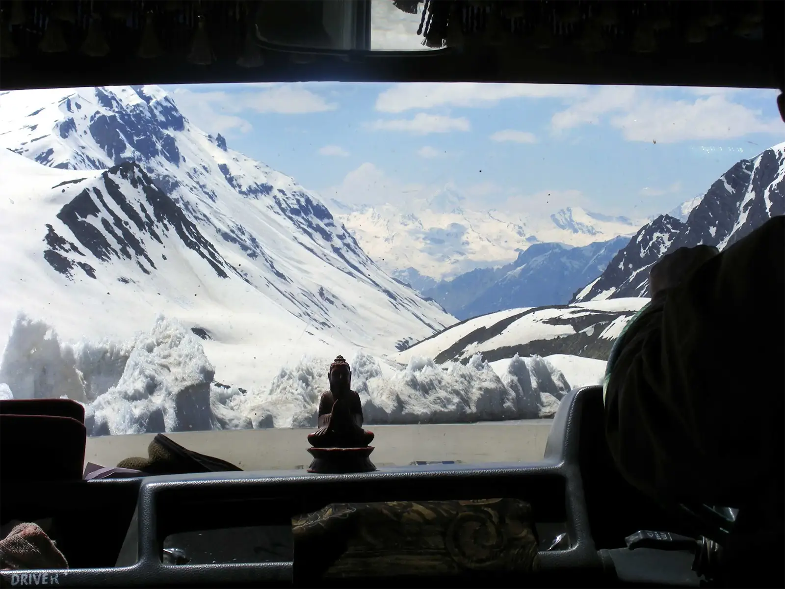 Statuette de Bouddha sur le tableau de bord face aux montagnes enneigées, route Leh–Manali