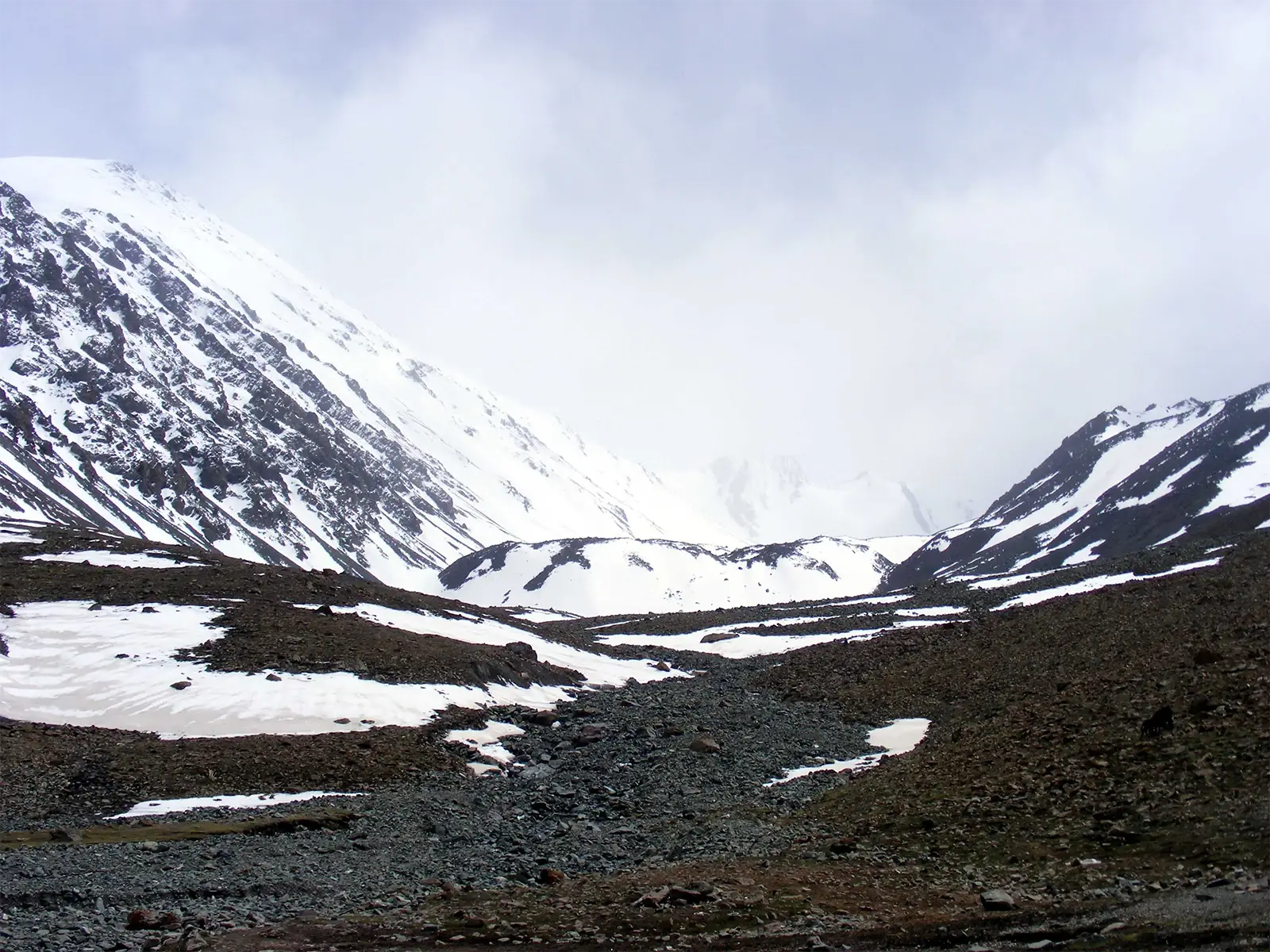 Vallée enneigée sous les nuages en montant vers le camp de base du Stok Kangri