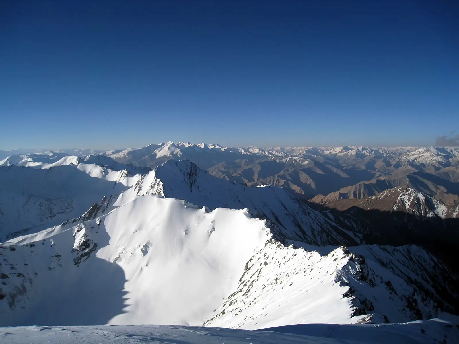 Crêtes enneigées et panorama sur l’Himalaya depuis l’arête sommitale du Stok Kangri
