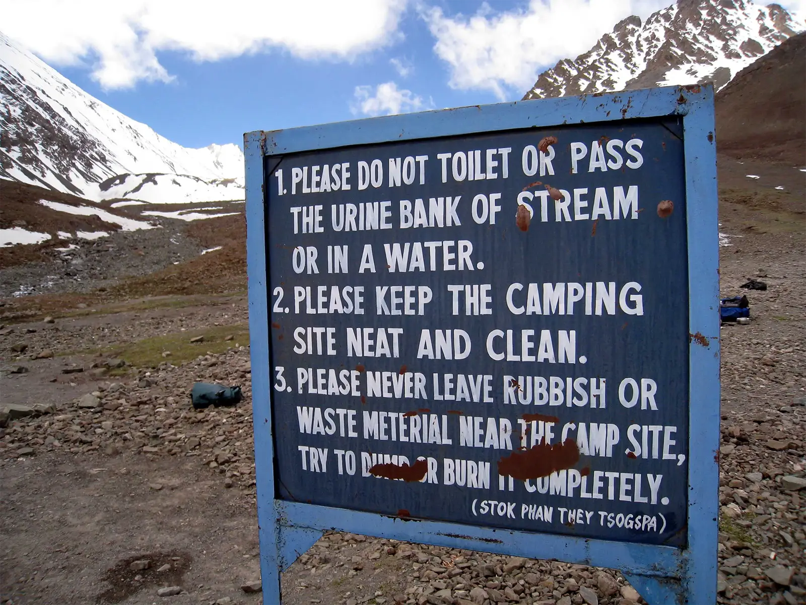 Panneau de consignes de propreté dans un camp du trek du Stok Kangri, face aux sommets