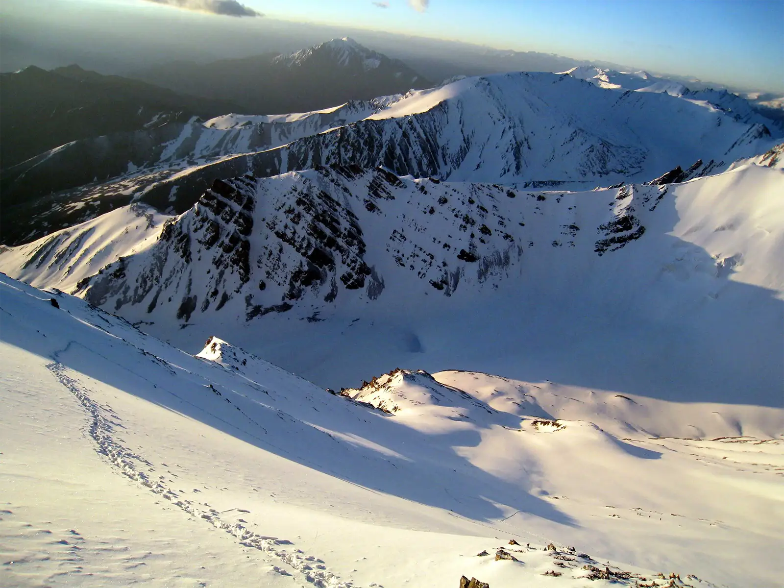 Traces de pas dans la neige au lever du jour pendant l’ascension du Stok Kangri