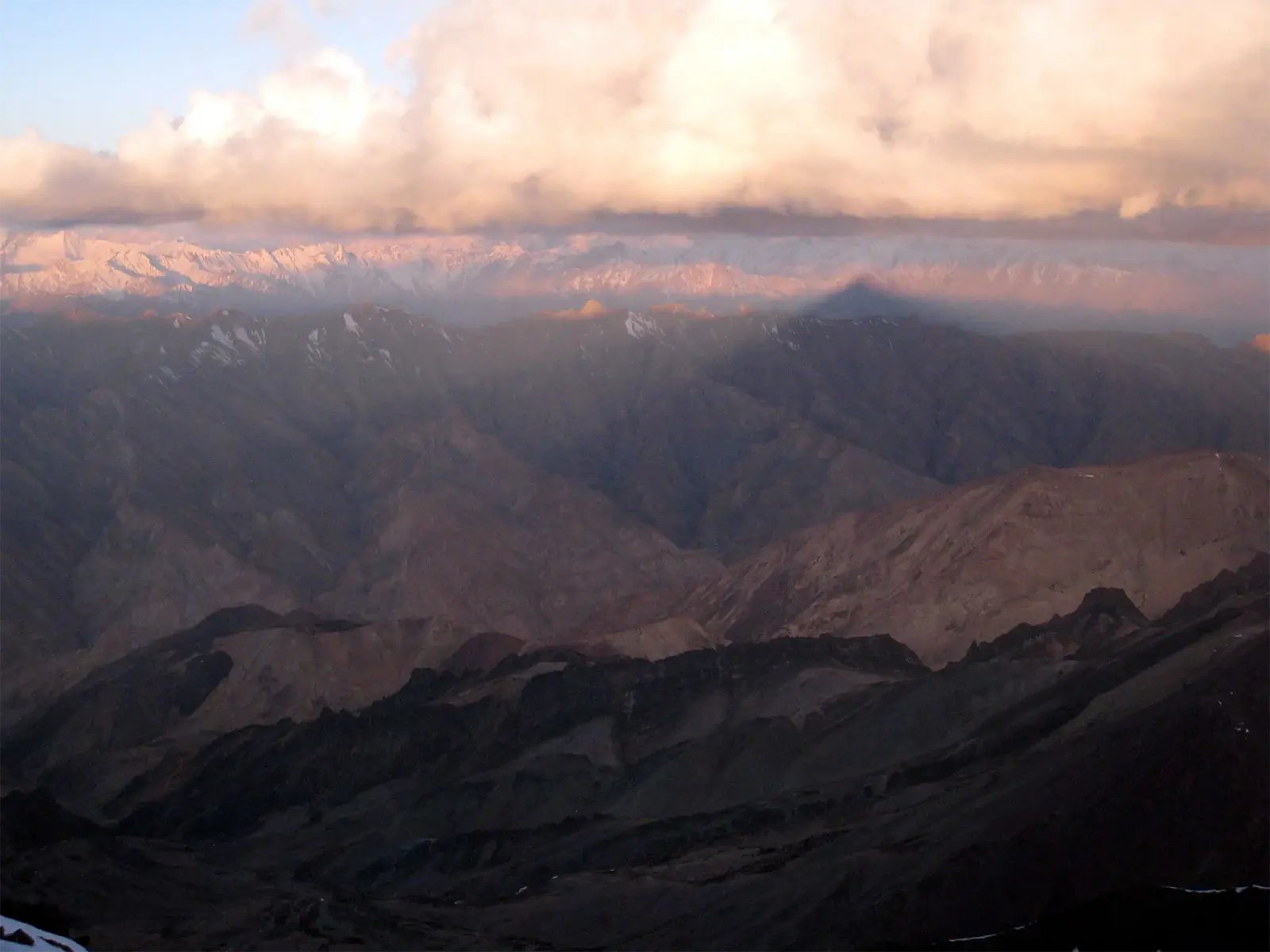 Ombre du Stok Kangri projetée sur les montagnes du Ladakh et du Zanskar au lever du soleil
