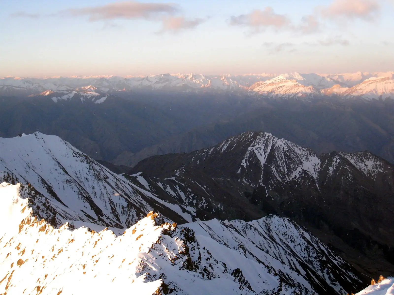 Vue du sommet du Stok Kangri à 6 153 m sur les chaînes enneigées au soleil levant