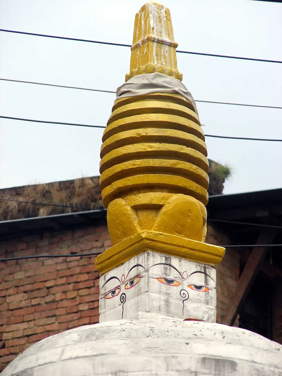 Petit stupa blanc aux yeux de Bouddha et à la flèche jaune dans une ruelle de Bhaktapur