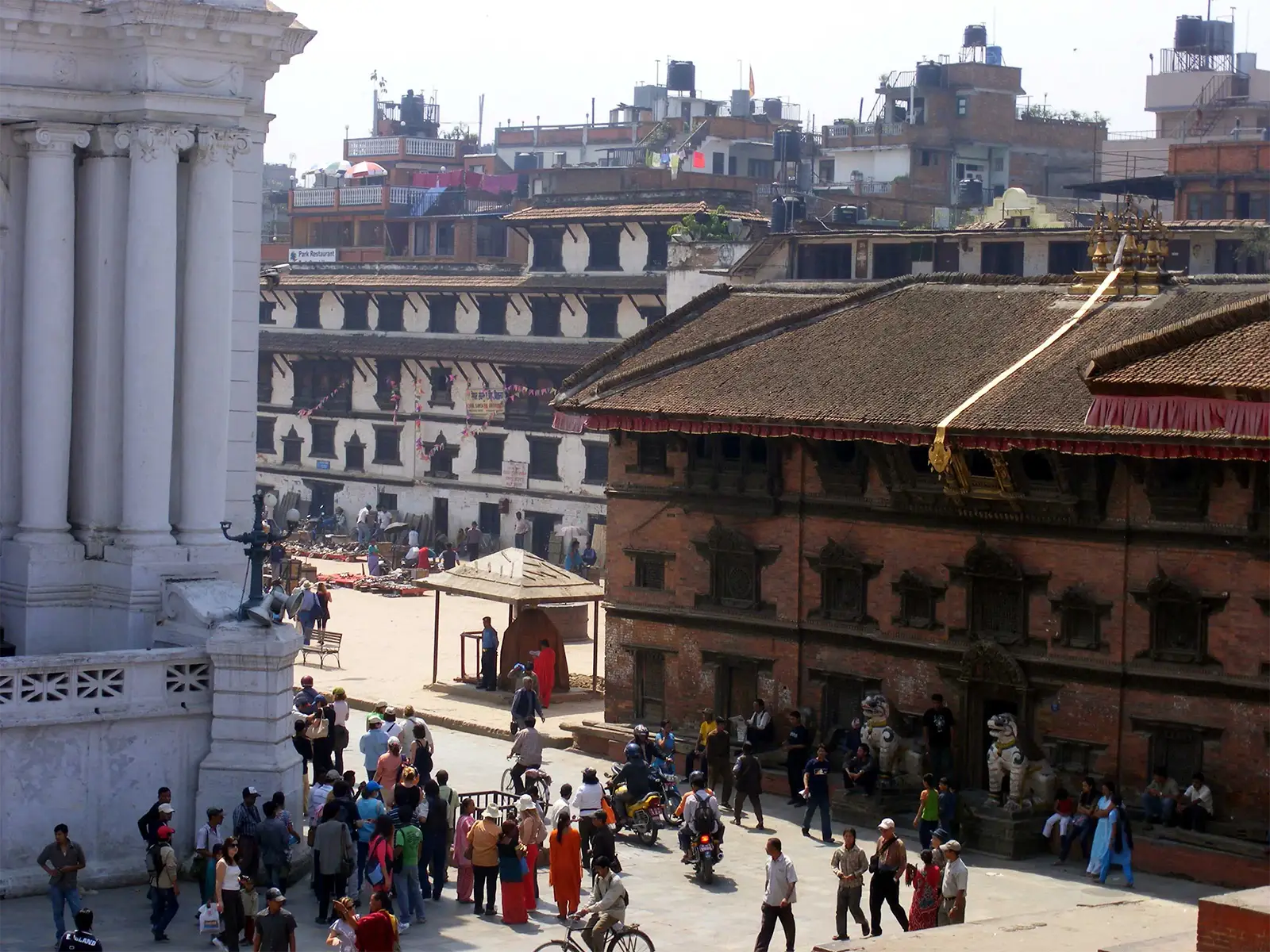 Foule et bâtiments anciens de briques et de stuc blanc sur le Durbar Square de Katmandou