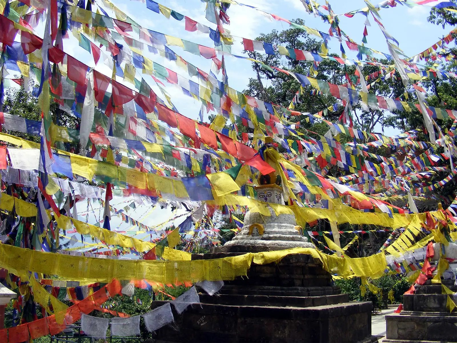 Drapeaux de prières multicolores tendus au-dessus d’un petit stupa à Katmandou