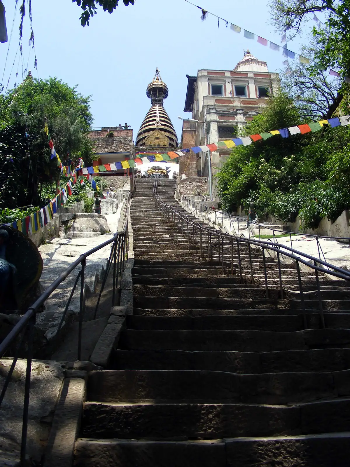 Le long escalier qui monte vers le stupa de Swayambhunath à Katmandou, sous les drapeaux de prières