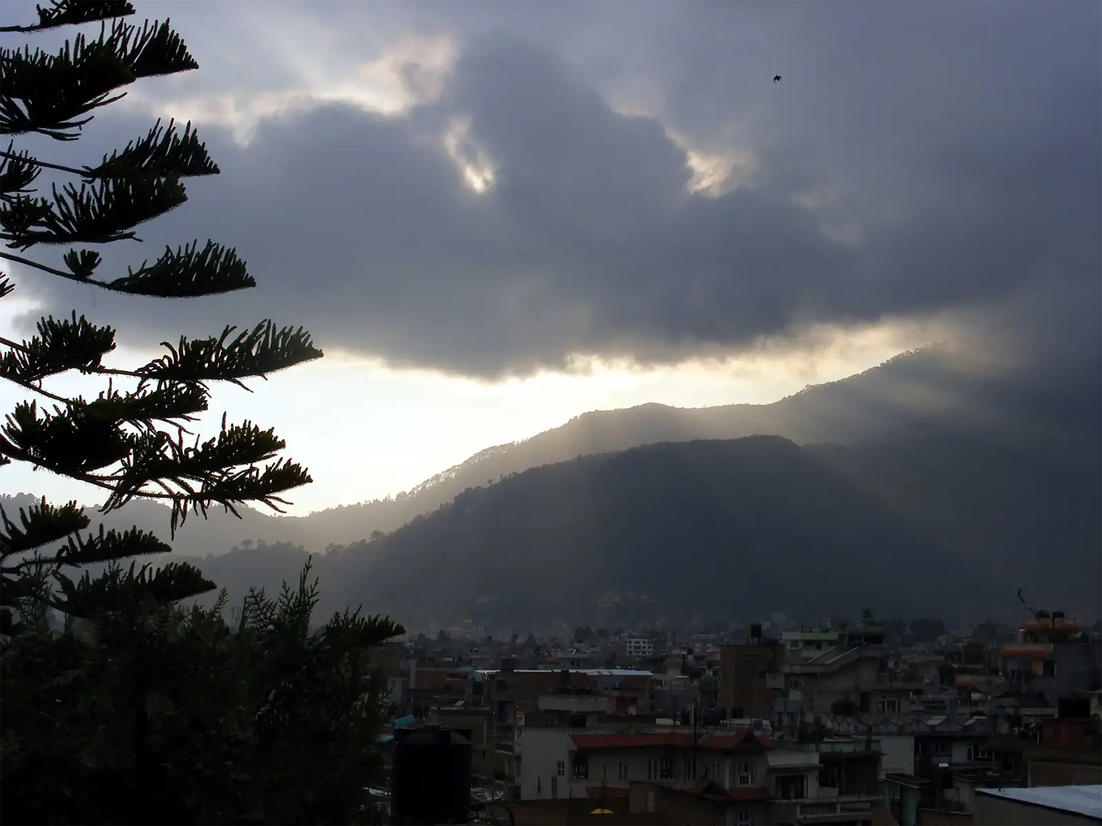 Rayons de soleil perçant les nuages au-dessus des collines et des toits de Katmandou