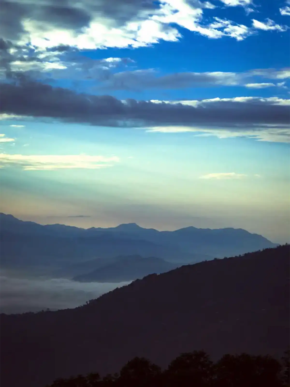Crêtes bleutées et mer de nuages dans la vallée, au petit matin à Nagarkot