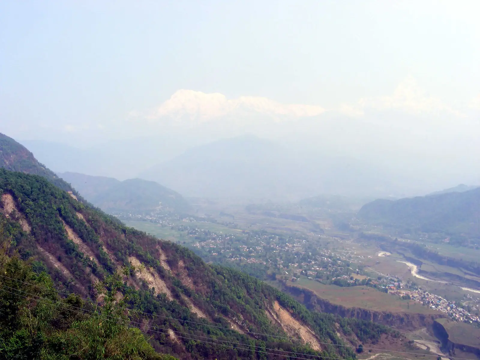 Vallée de Pokhara vue des hauteurs, un sommet enneigé à peine visible dans la brume