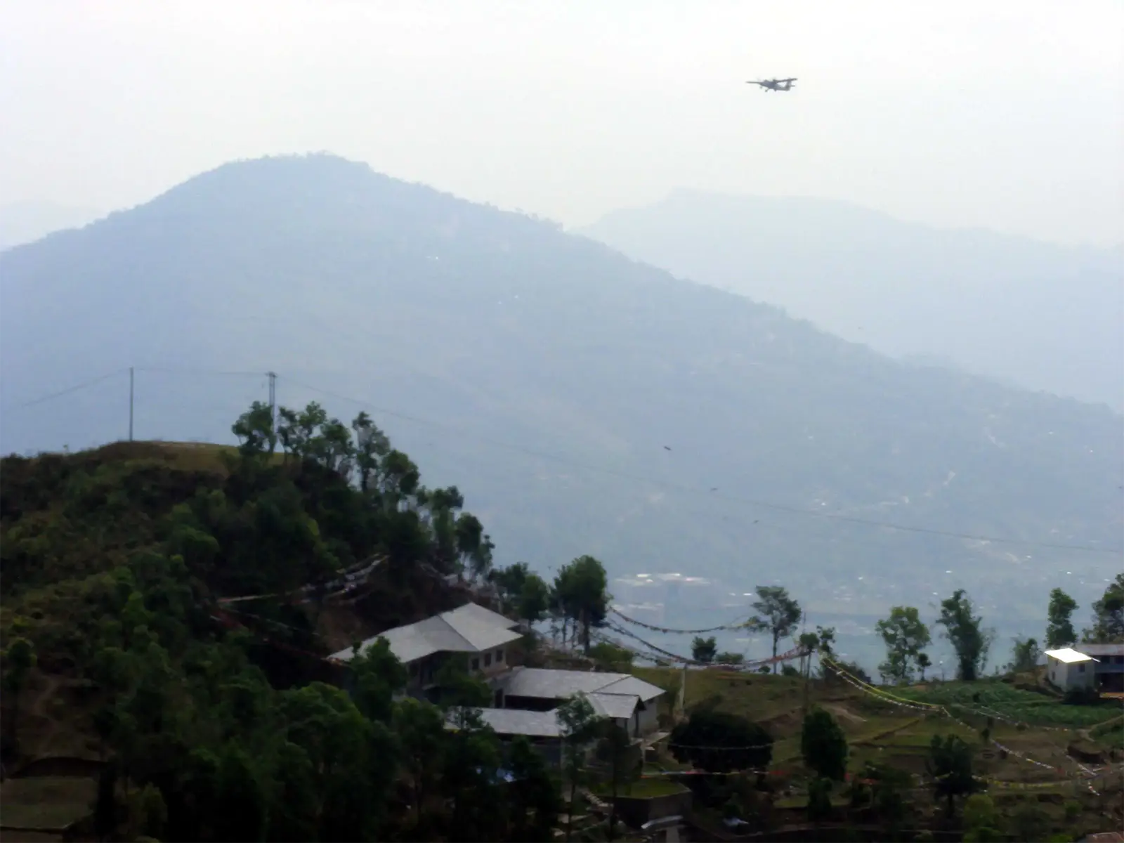 Petit avion survolant les collines brumeuses au-dessus de Pokhara