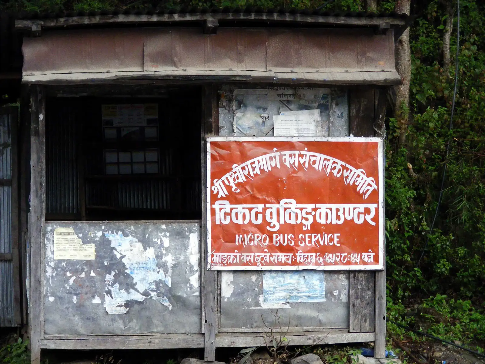 Guichet de micro-bus à la pancarte rouge en népali sur la route du trek des Annapurnas