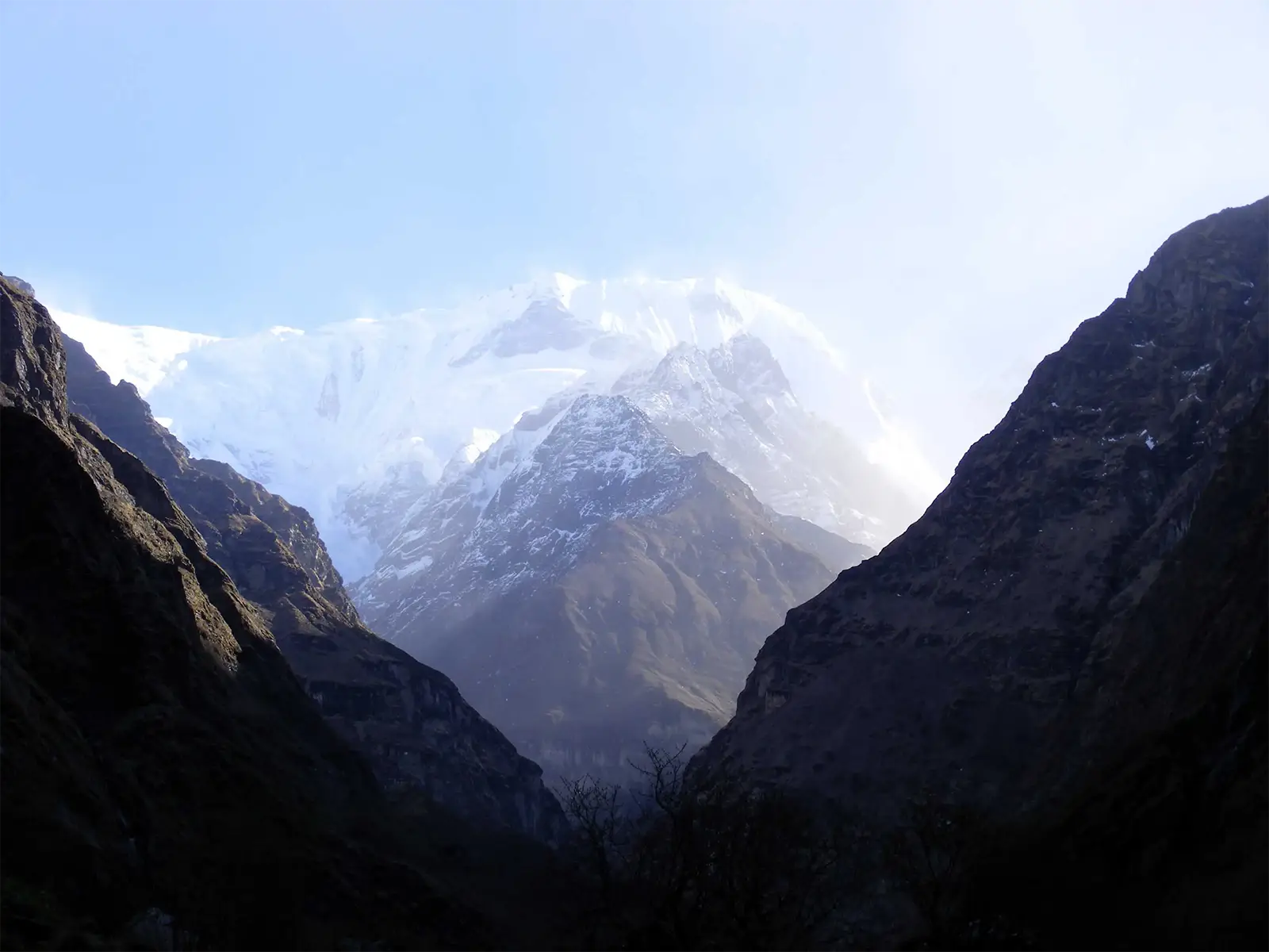 Sommets enneigés baignés de lumière entre deux versants sombres, à l’entrée du sanctuaire des Annapurnas