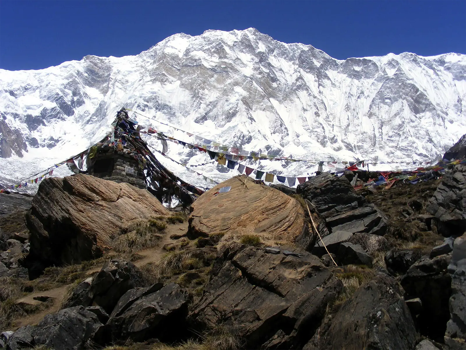 Drapeaux de prières et rochers au camp de base des Annapurnas, face à l’Annapurna I
