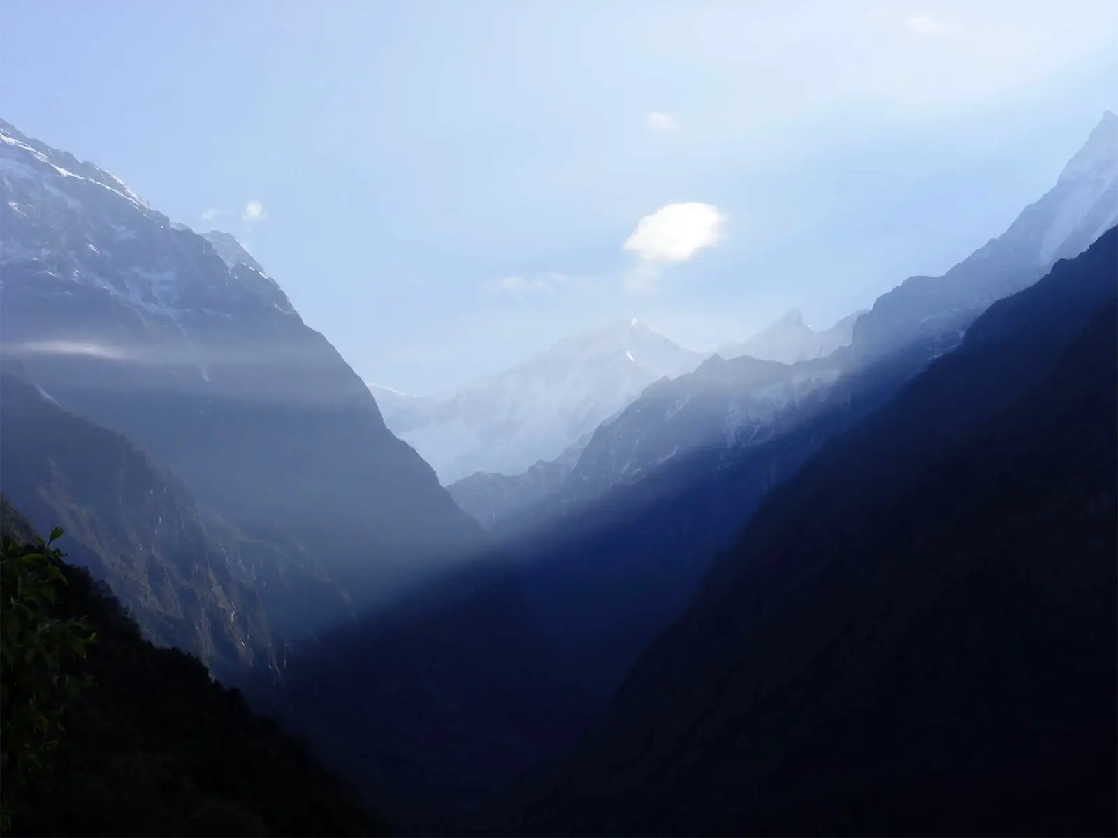 Rayons du soleil levant dans une vallée encaissée entre les sommets du sanctuaire des Annapurnas