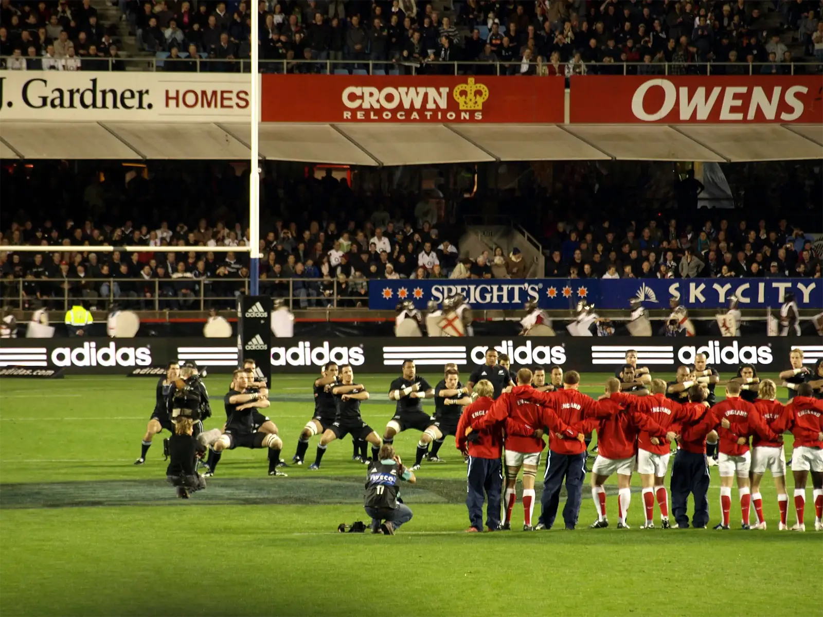 Haka des All Blacks face à l’équipe adverse en maillot rouge, au stade Eden Park d’Auckland