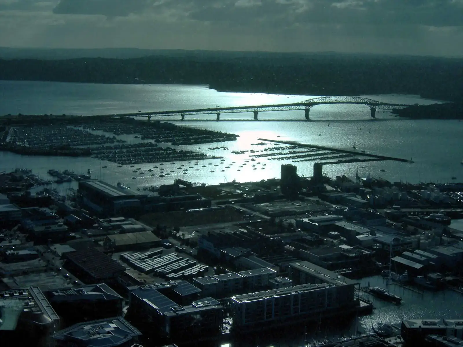 Le Harbour Bridge d’Auckland et la marina à contre-jour, vus du haut de la Sky Tower