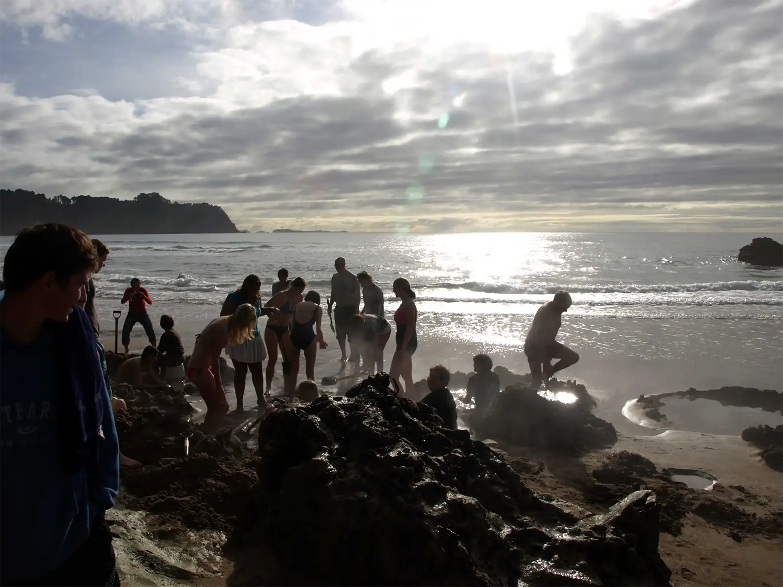 Baigneurs creusant leur bassin d’eau chaude dans le sable de Hot Water Beach, péninsule de Coromandel