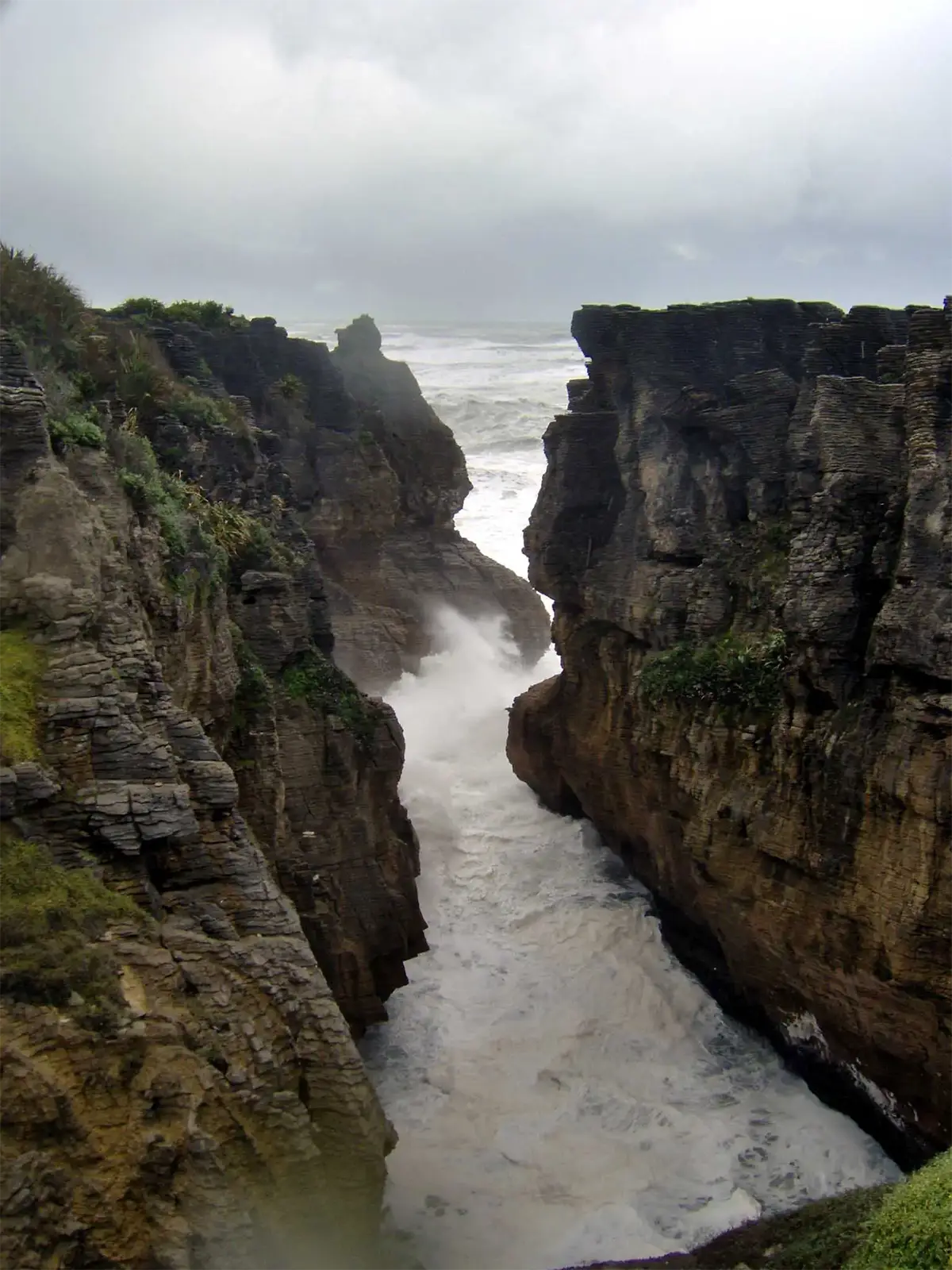 Vagues s’engouffrant dans une gorge étroite entre les falaises des Pancake Rocks de Punakaiki
