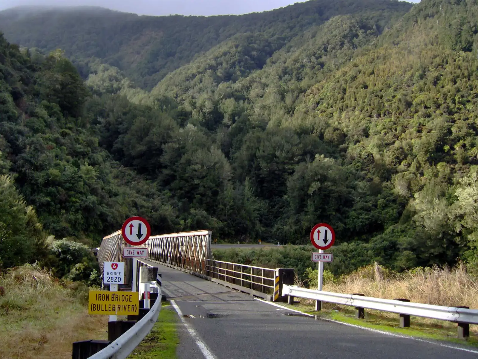 Pont métallique à voie unique de l’Iron Bridge sur la rivière Buller, entre les collines boisées